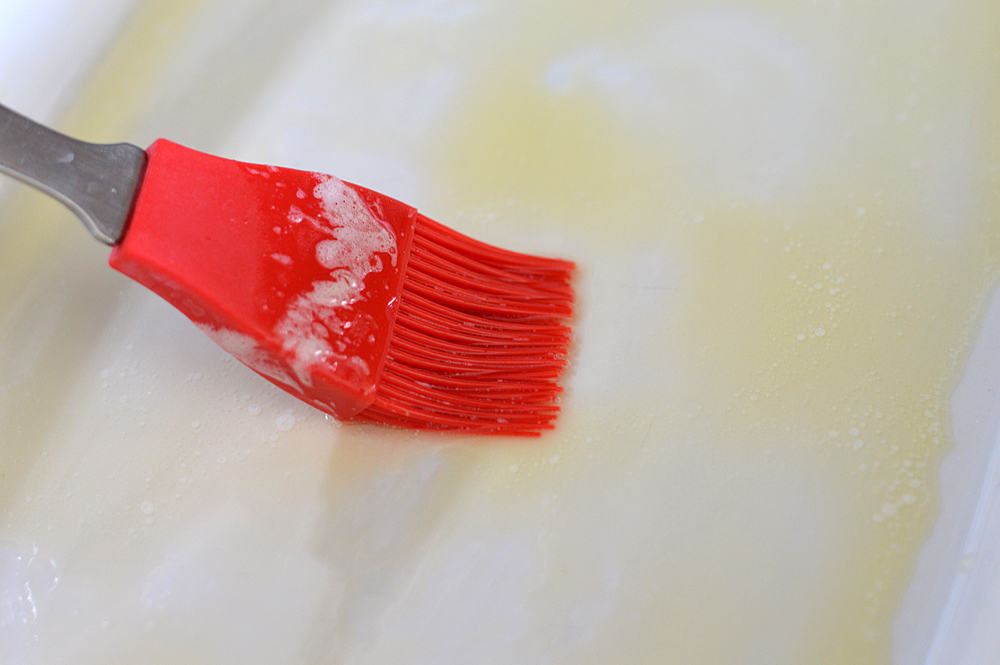 Brushing melted butter on phyllo for Spanakopita {Vegan}