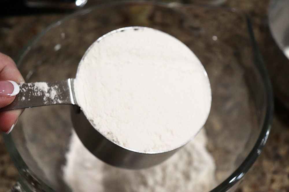 Adding flour to a mixing bowl