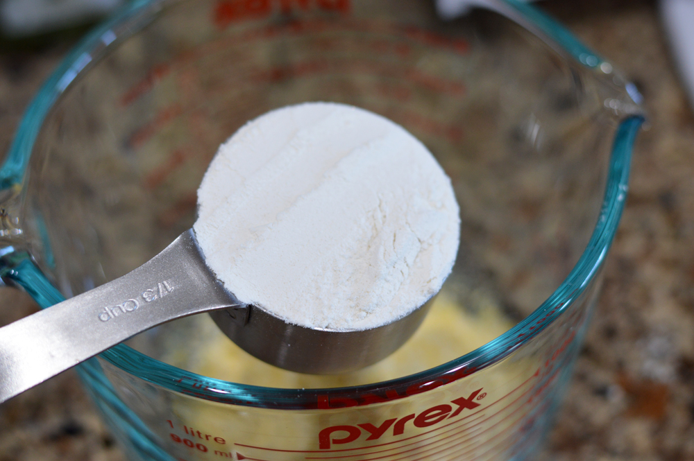 Measuring cup full of flour for Vegan Corn Fritters