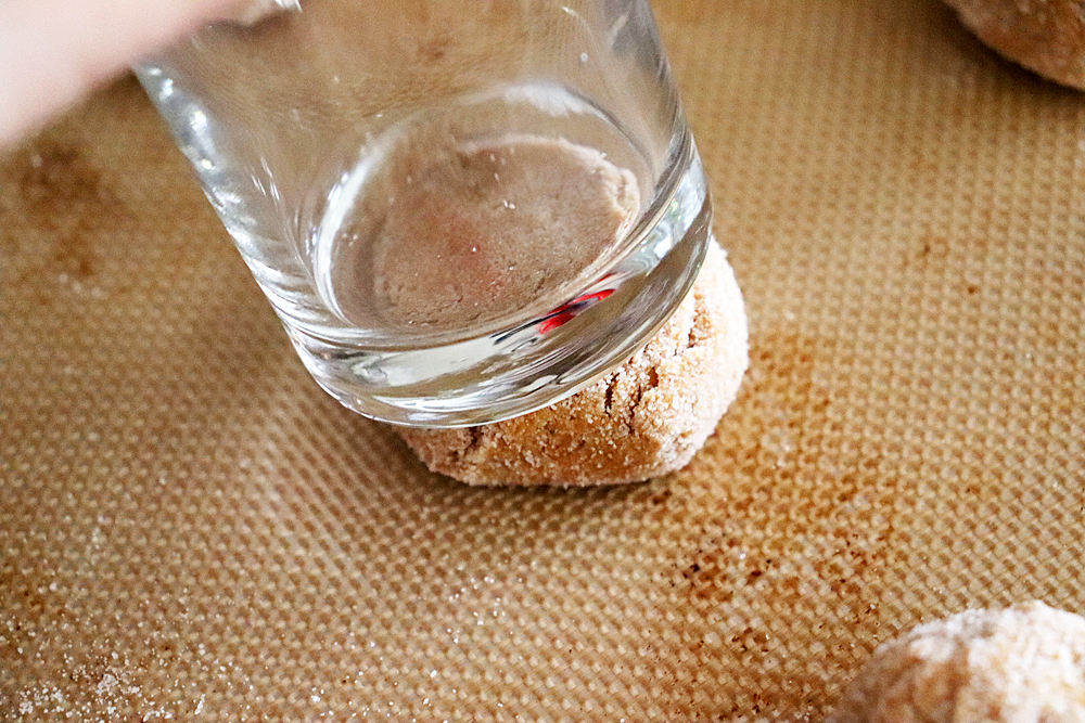 Pressing the dough balls with a juice glass