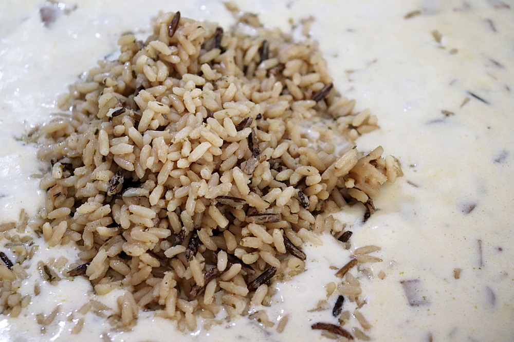 Adding cream and wild rice mix to sauteed vegetables