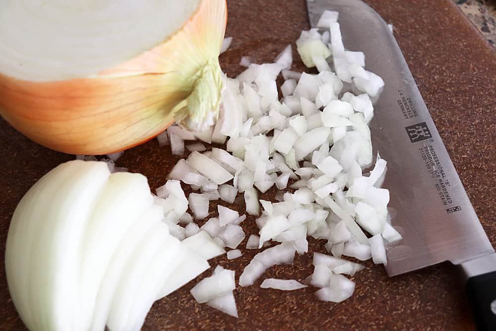 Diced onions with a knife on a cutting board