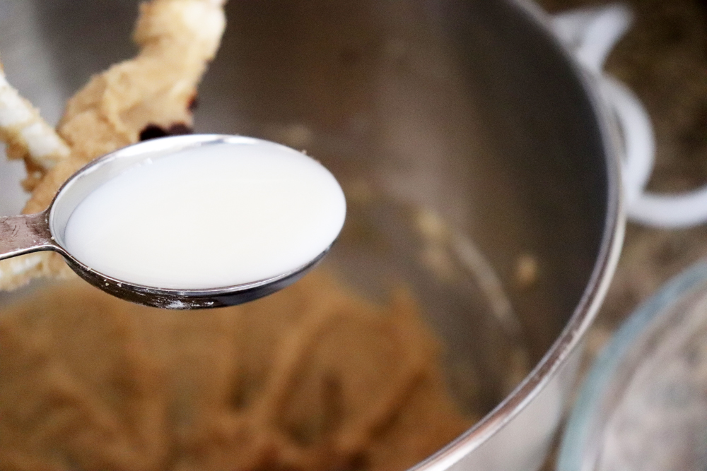 Adding almond milk to creamed butter and sugar mixture