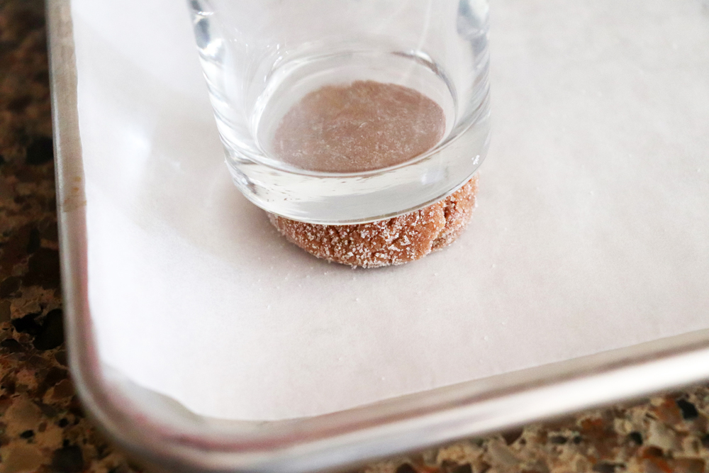 Pressing cookie dough into a round with a juice glass