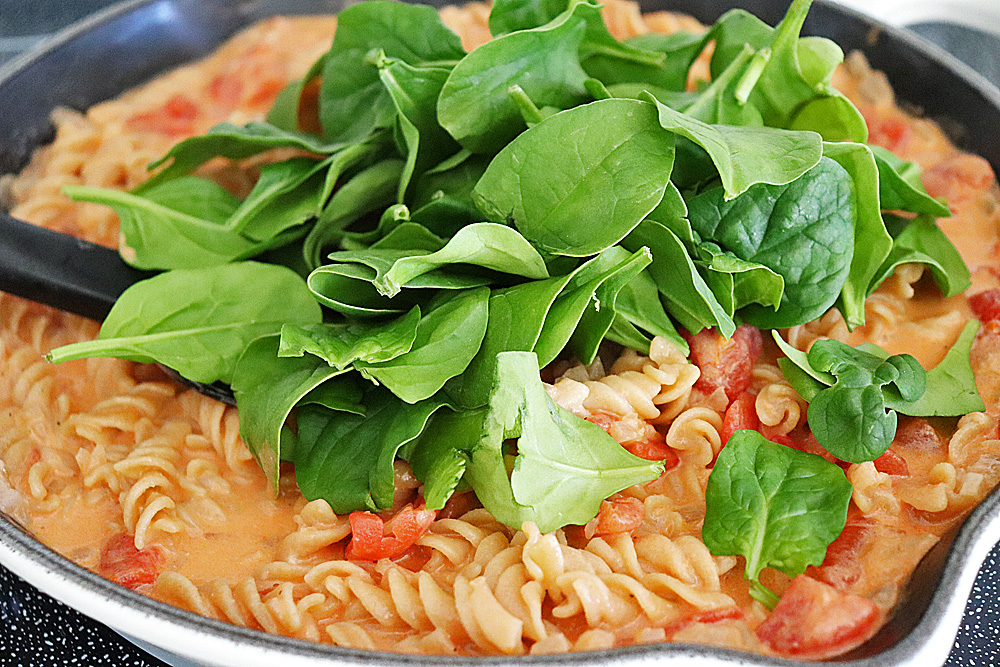 Adding fresh spinach to the pasta