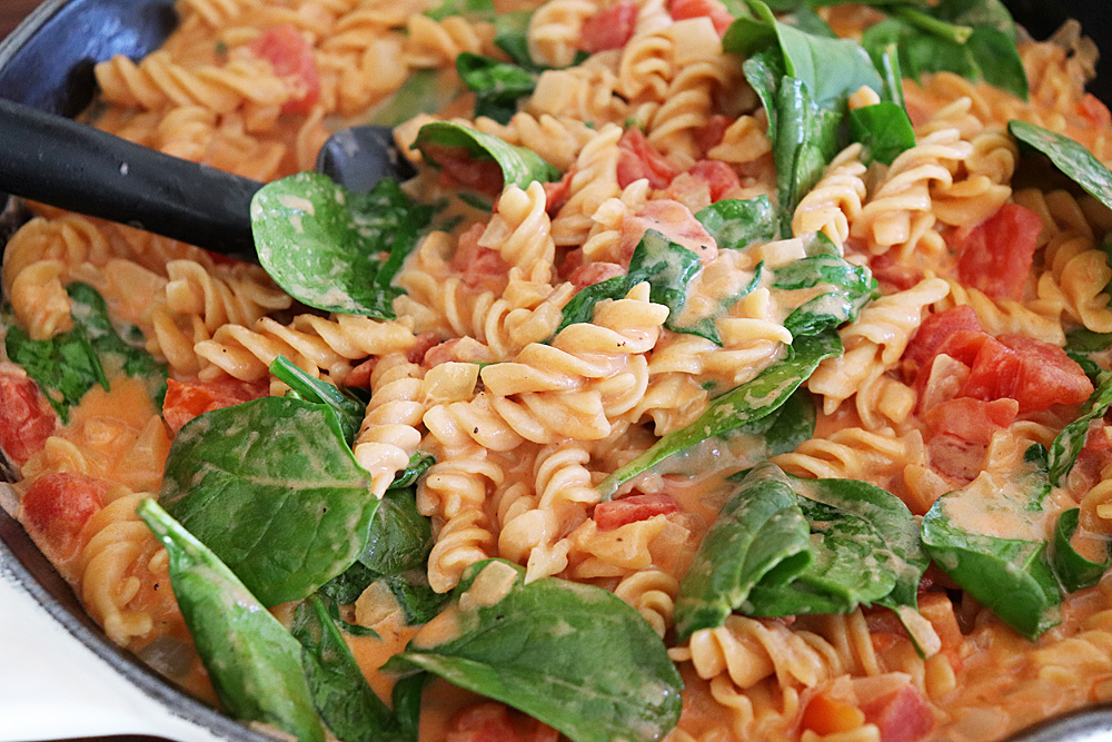 Wilted spinach in pasta with tomato cream sauce