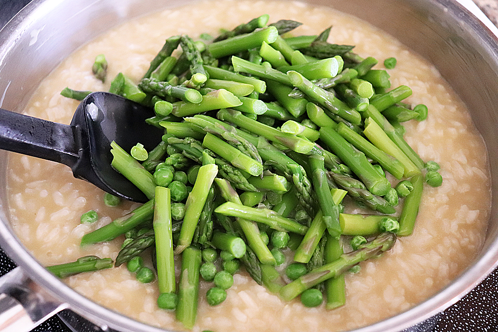 Adding asparagus into cooked rice for <img class="aligncenter size-full wp-image-15342" src="https://theveglife.com/wp-content/uploads/2019/03/Olive-oil-and-butter.jpg" alt="A tablespoon of oil and butter in a pan" width="1000" height="796" />