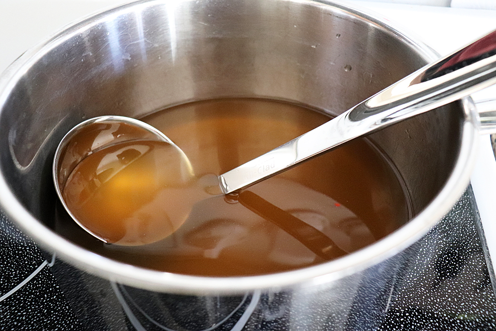 Broth with a ladle in pan