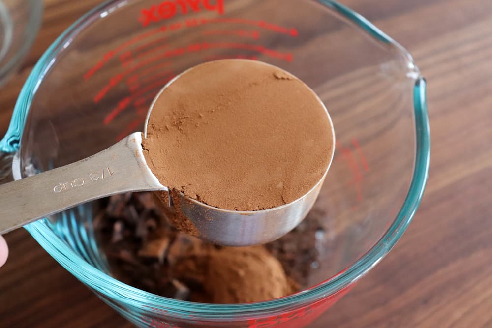 Measuring cup full of cocoa powder for Easy Vegan Brownies