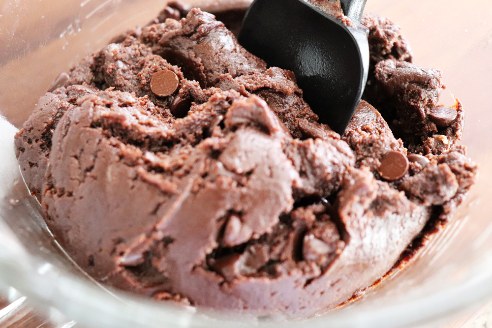 Folding chocolate chips into brownie batter for Easy Vegan Brownies