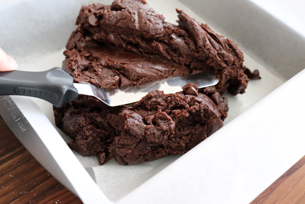 Using an offset spatula to spread brownies in a pan for Easy Vegan Brownies