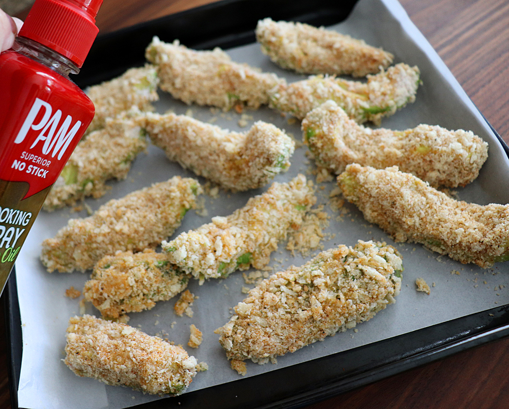 Spraying Crispy Baked Avocado Fries with avocado spray