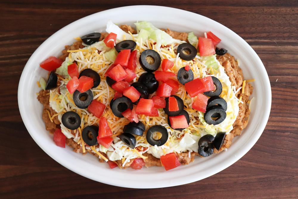 Adding tomatoes to olive layer