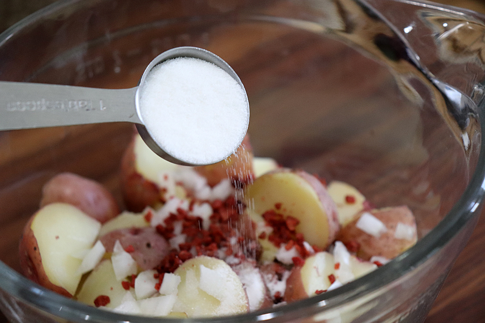 Adding white sugar to the potatoes