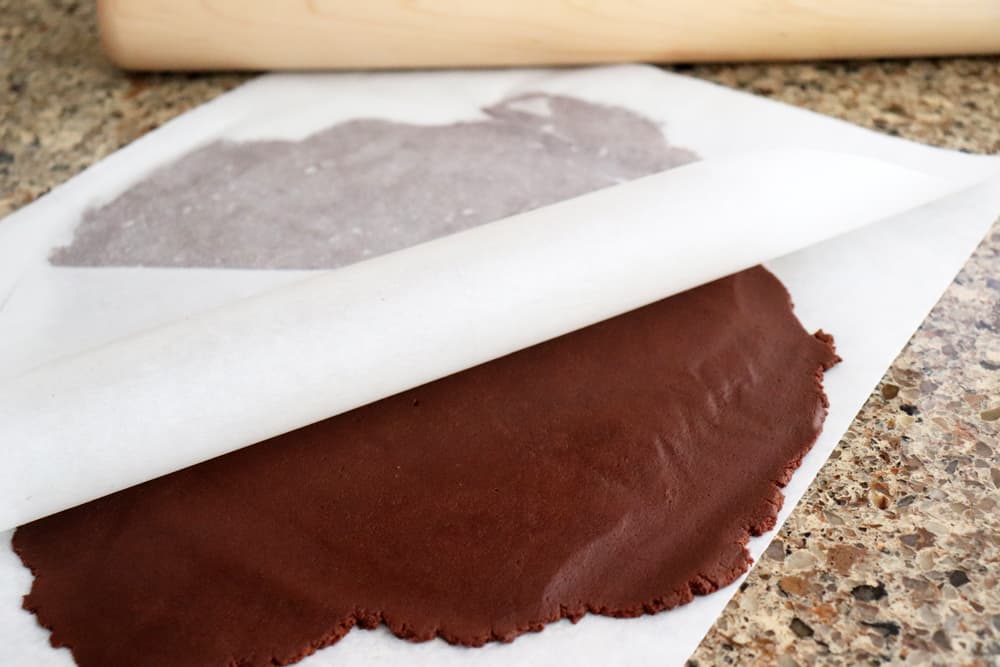 Rolling out dough between two sheets of parchment for Vegan Chocolate Sugar Cookies