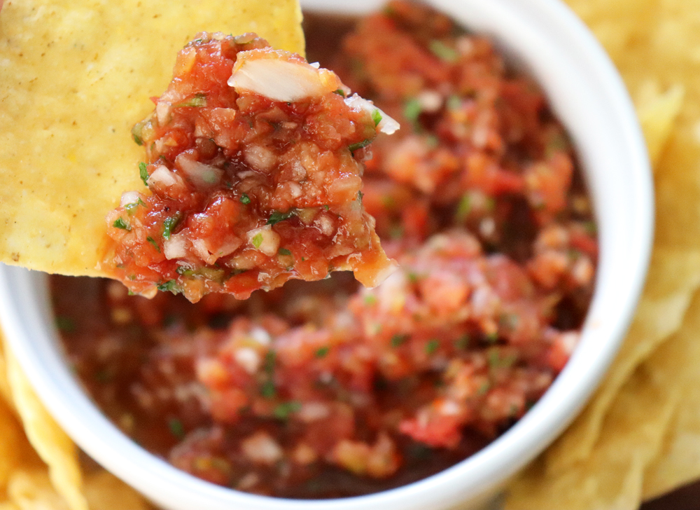 Tortilla chip dipped into Easy Restaurant Style Blender Salsa