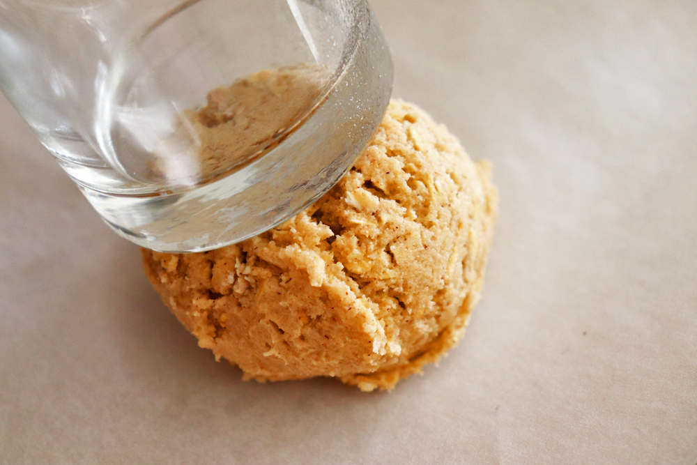 Pressing the dough flat with a juice glass