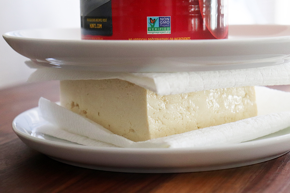 Pressing the tofu between two plates