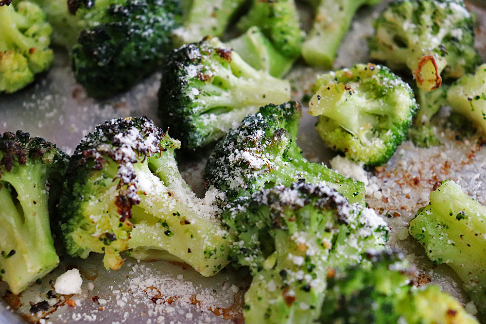 Adding vegan parmesan to the oven roasted broccoli