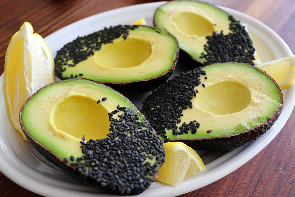 Dipping avocado in black sesame seeds